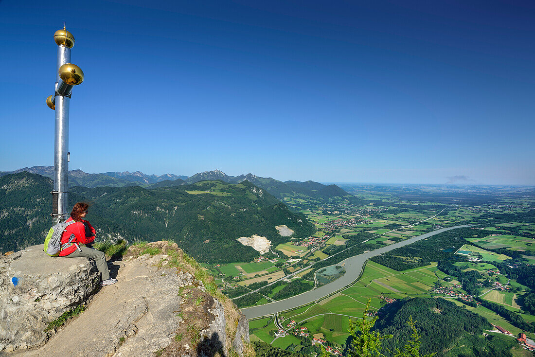 Woman sitting on summit of Kranzhorn and looking over Inn valley, Chiemgau Alps, Upper Bavaria, Bavaria, Germany