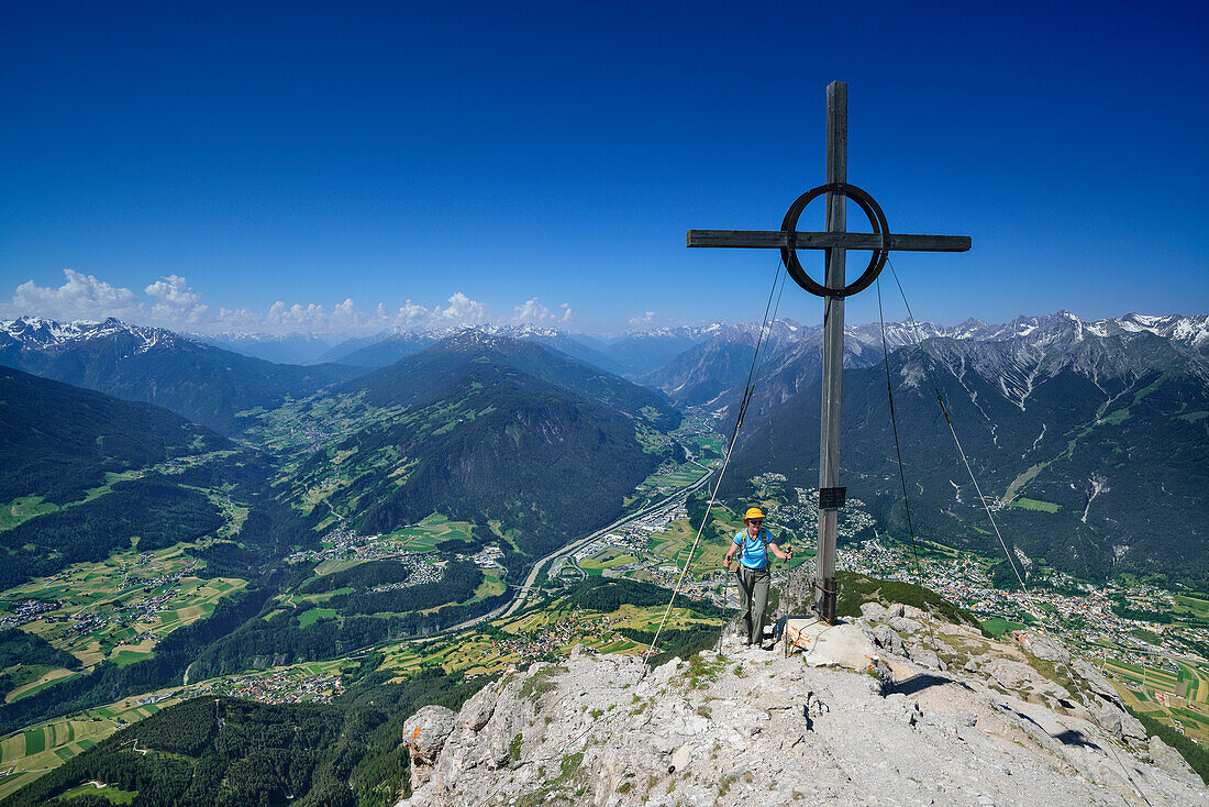 Woman beside summit cross on Tschirgant, Mieming Range, Tyrol, Austria