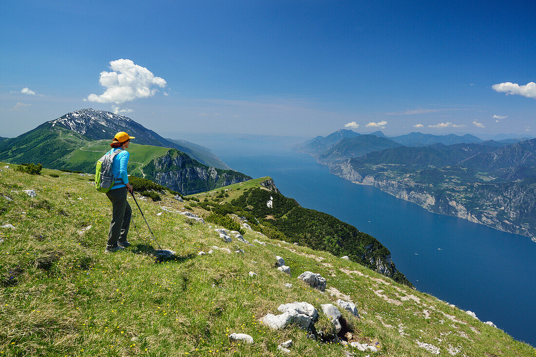 Female hiker looking over Monte Baldo and lake Garda, Monte Altissimo, Garda Mountains, Trentino, Italy