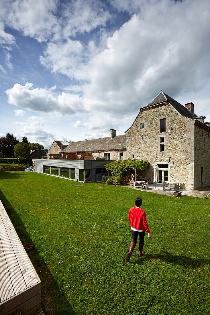 Woman in the garden of Le Cor de Chasse, food hotel by Michelin starred gourmet chef Mario Elias, manor house built in 1681 in Durbuy, Rue des Combattants 16, Weris, Wallonia, Belgium