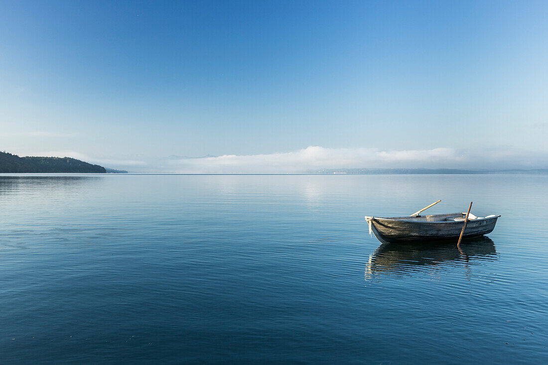 Rowing boat on Lake Starnberg, the Alps and Zugspitze in early morning fog, Berg, Upper Bavaria, Germany