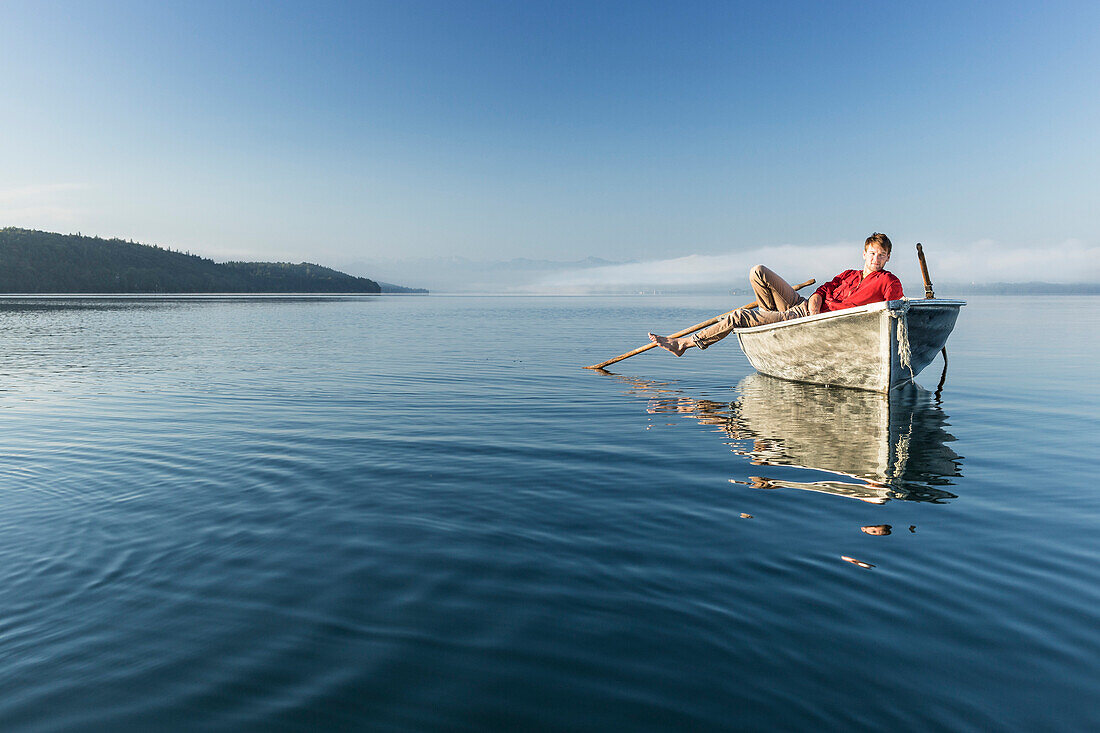 Mann in einem Ruderboot auf dem Starnberger See, Alpen mit Zugspitze im Morgennebel, Berg, Oberbayern, Bayern, Deutschland