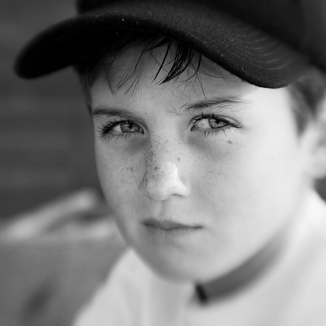 Junge mit einer Kappe blickt ernst in die Kamera (Schwarzweißaufnahme unter Nutzung von Lensbaby-Technik), Borden, Western Australia, Australien