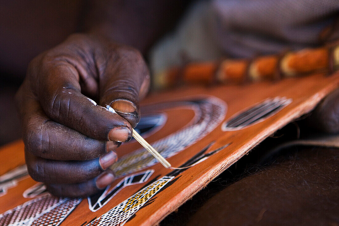 Nahaufnahme von Hand eines Aborigine Ureinwohner der mit einem altertümlichen Pinsel einen Fisch malt, Arnhem Land, Northern Territory, Australien
