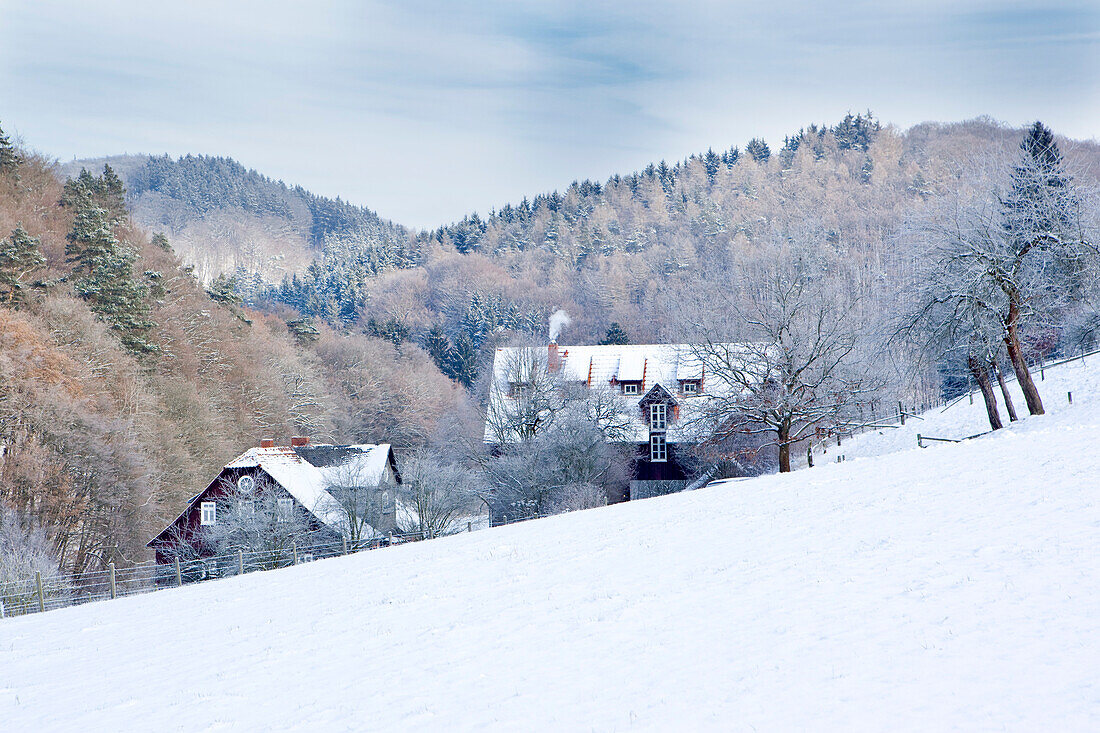 Idyllic winter scene with Kuchenmuehle watermill in the snow in Lengeltal valley in Kellerwald-Edersee National Park, Frankenau, Hesse, Germany, Europe