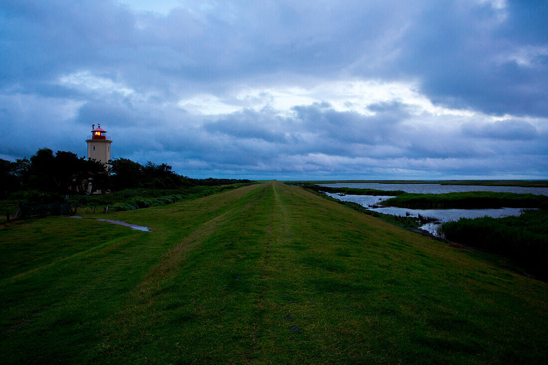 Leuchtturm Westmarkelsdorf, auch Leuchtfeuer am Hakenorth, Blick über den Deich mit dunklem Himmel, Westmarkelsdorf, Fehmarn, Meckenburg-Vorpommern, Deutschland, Europa