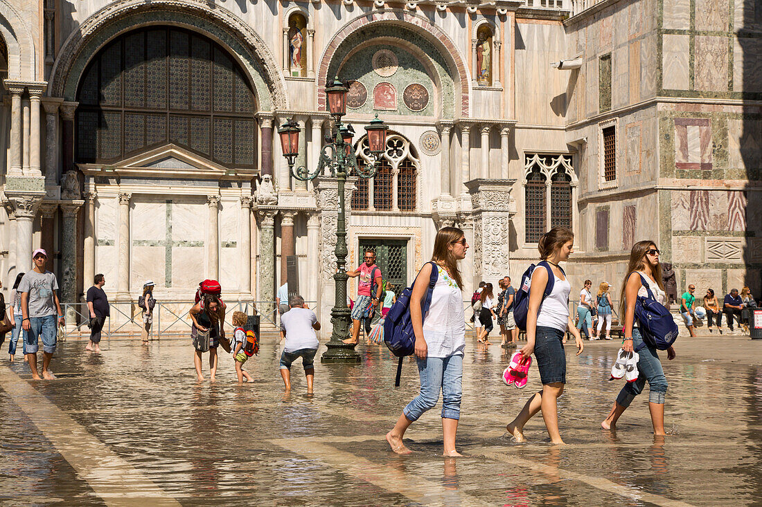 Menschen waten durch knöcheltiefes Wasser eines überfluteten Markusplatz, Venedig, Venetien, Italien, Europa