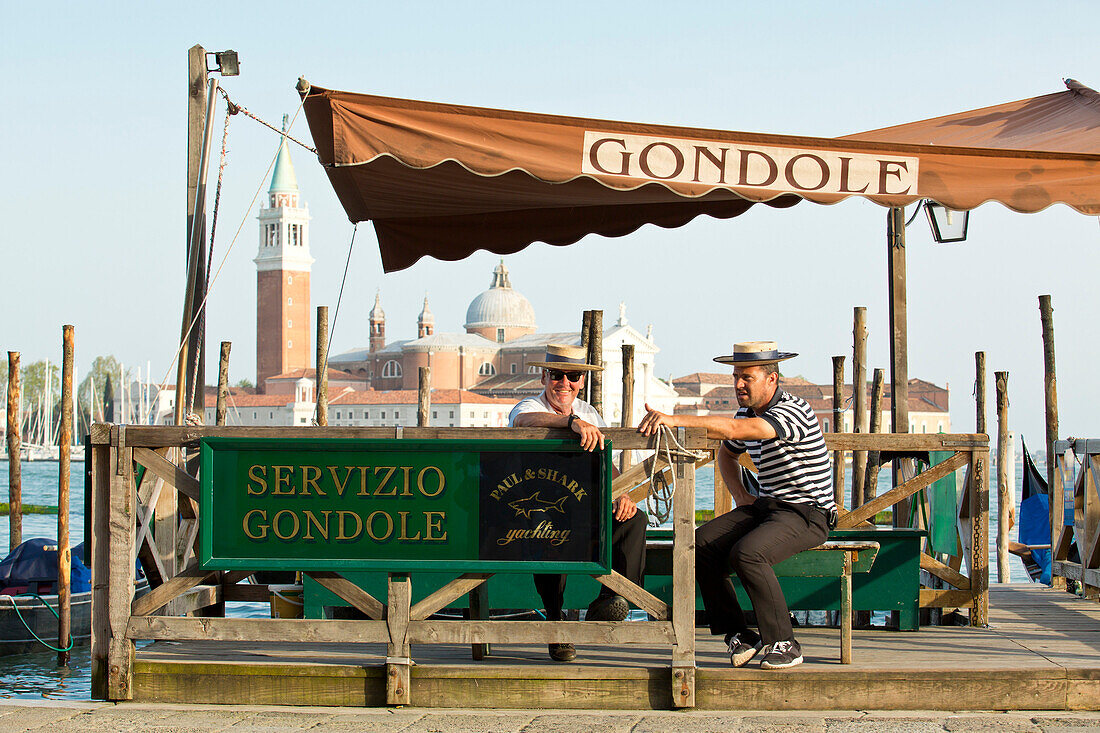 Gondoliers along San Marco Basin waiting for clientele, Venice, Veneto, Italy, Europe
