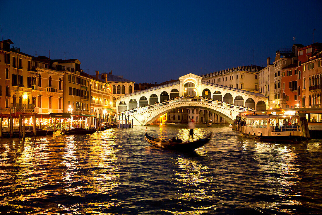 Silhouette einer Gondel am Canal Grande vor der beleuchteten Rialtobrücke in der Dämmerung, Venedig, Venetien, Italien, Europa
