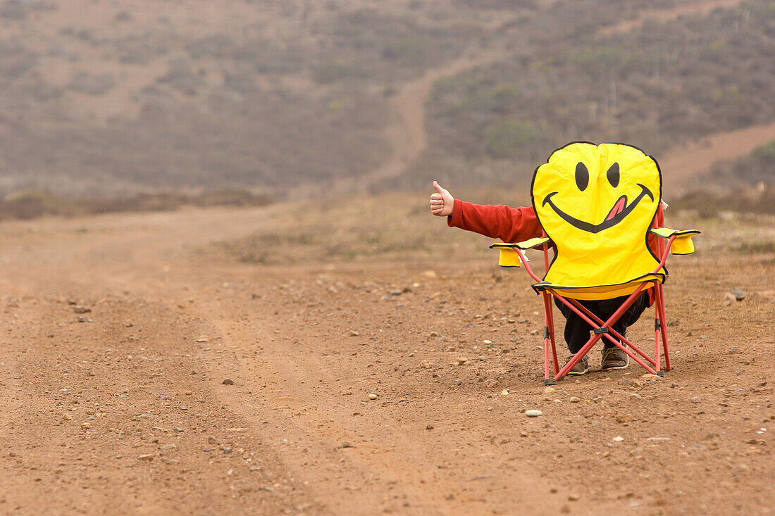 Chris Twomey hitch hiking behind happy face chair in Baja Norte, Mexico.  Justin Bailie / Aurora Photos 
