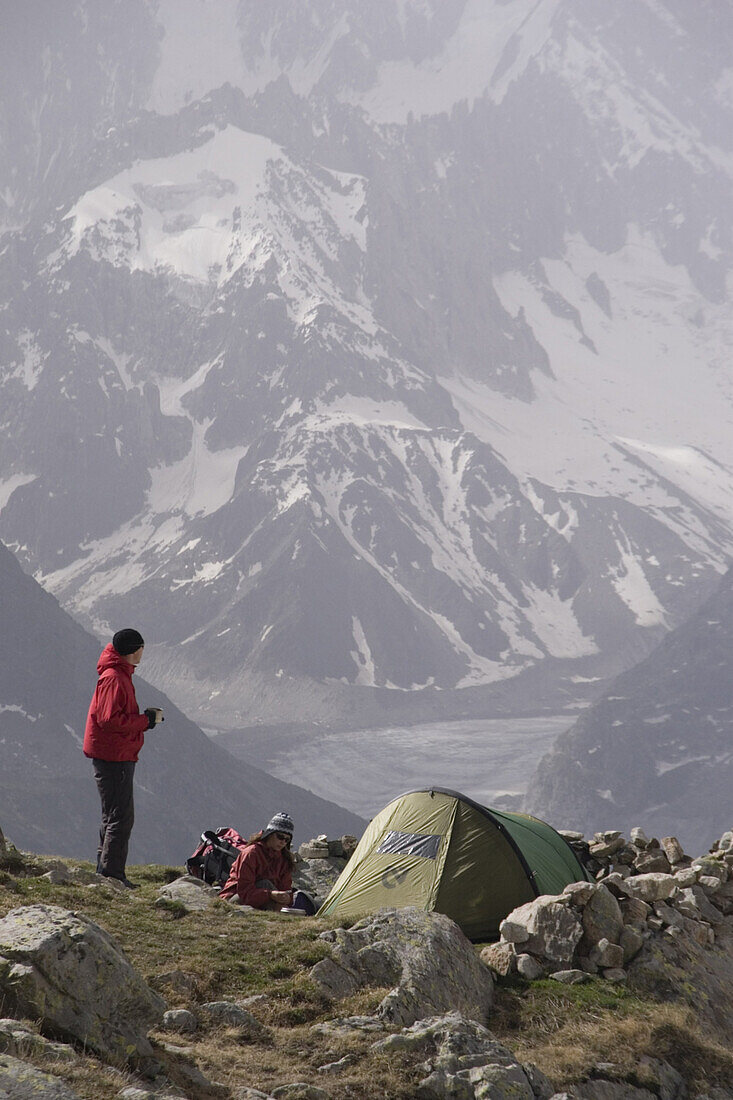 A couple camping near Mont Blanc in bad weather in the French Alps.