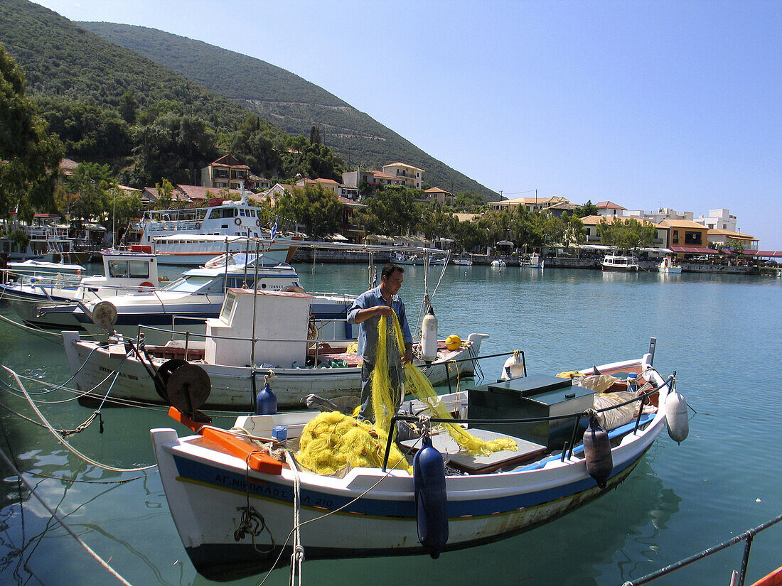 A man on a boat in the small village of Vassiliki on the Island of Lefkas in Greece.