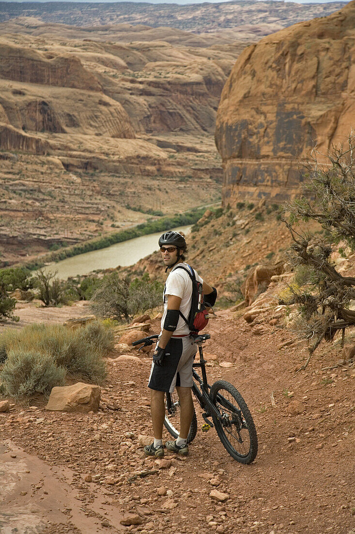 Mark Trevithick standing with his bike on the Portal trail, Moab, Utah. The portal trail is know for it's exposure and cliffs. A few mountain bikers have died on this trail falling off the cliff.
