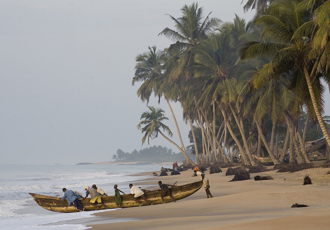 Brenu - Akyinim, GHANA : Fishermen heading out to sea.  The fishing village of Brenu-Akyinim is located 10 km west of Elmina and features a long  sandy beach lined with palm trees often packed with fishermen and their boats.   Photo by: Christopher Herwig