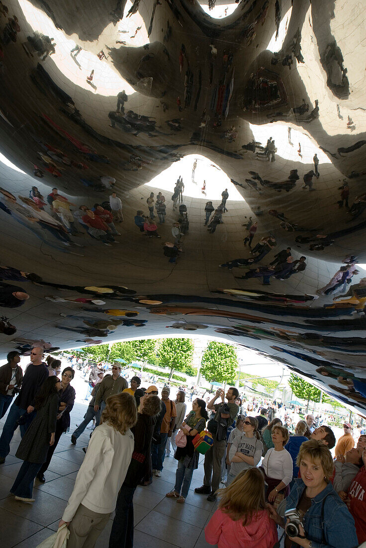 'People crowd around Anish Kapoor's ''Cloud Gate'' aka ''The Bean'' in Chicago's Millennium Park. People crowd into the ''gate'' space beneath the sculpture.'