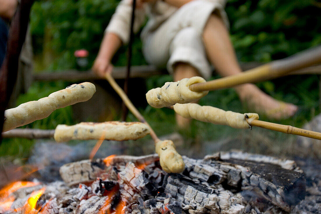 Food on skewers is cooked over a campfire in Denmark.