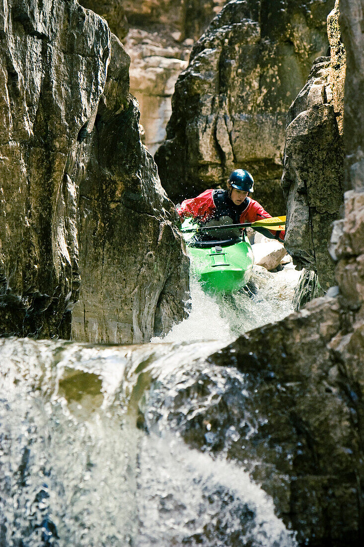 Tanner Duff kayaking the tight slot canyon of Cascade Falls near Durango Colorado, prepares for a waterfall with a 15 foot drop.