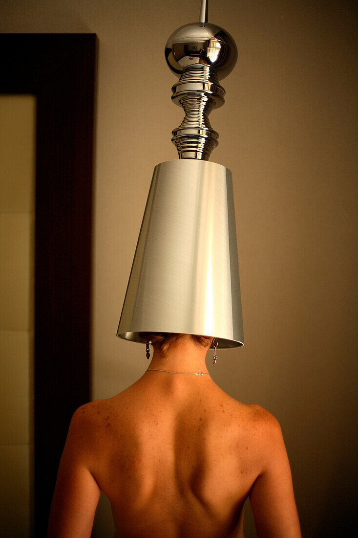 A woman stands under a stainless steel lamp shade in a hotel room in Prague, Czech Republic. hwilmeth_03.jpg