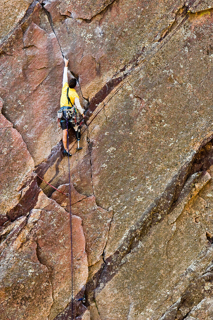 'Craig DeMartino; a climbing accident amputee, rock climbing in Eldorado Canyon State Park, doing the route, Werk Supp 5.9 near Boulder, Colorado.'