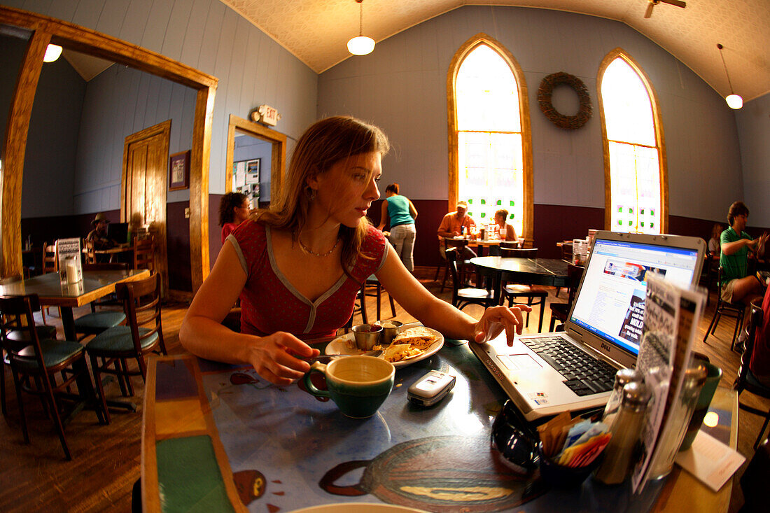 Lydia McDonald checks her email via laptop while eating breakfast at the Cathedral Cafe in downtown Fayetteville, WV