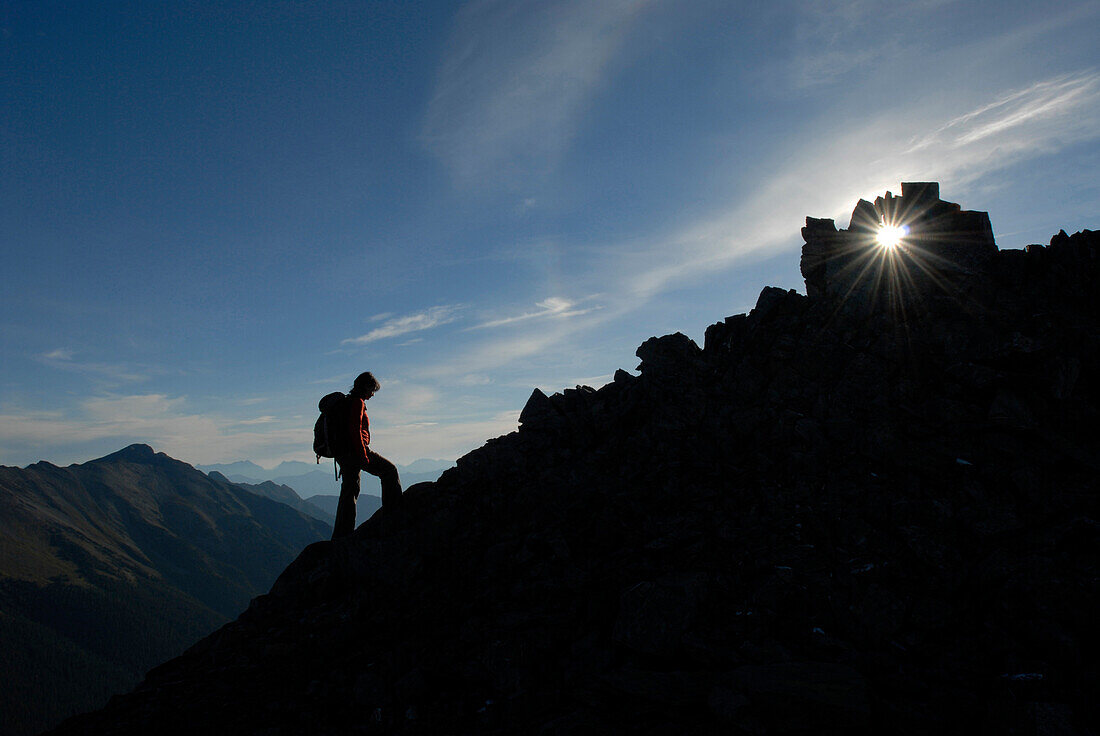 A sunset is caught between a rock outcrop during an evening hike, Canadian Rockies, British Columbia, Canada.