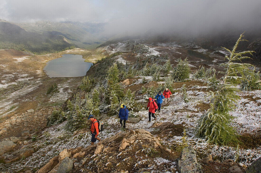 A hiking group catches an early season snow in the Canadian Rockies, British Columbia, Canada.