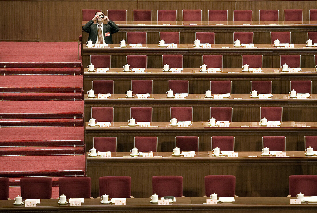 A delegate snaps a photo from his desk in the Great Hall of the People during a session of the National People's Congress, China's Parliament.