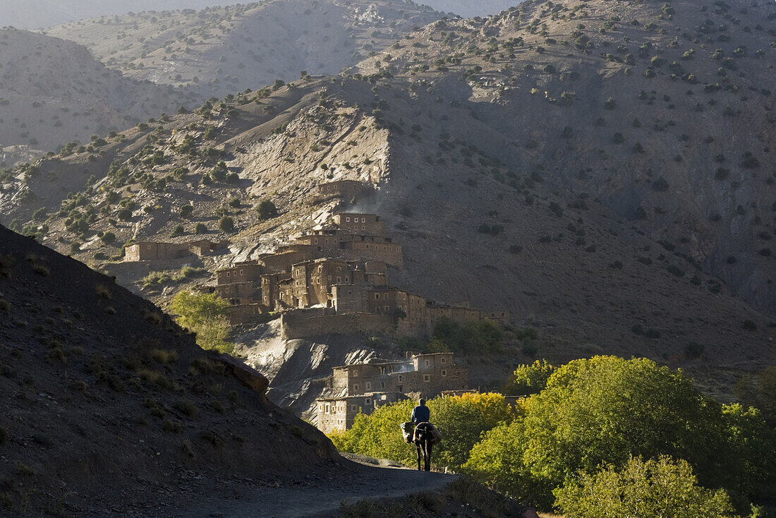 A man on horseback approaches the dramatic Berber village of Rougoult in the M'Goun Massif, Central High Atlas Mountains, Morocco on November 4, 2007.
