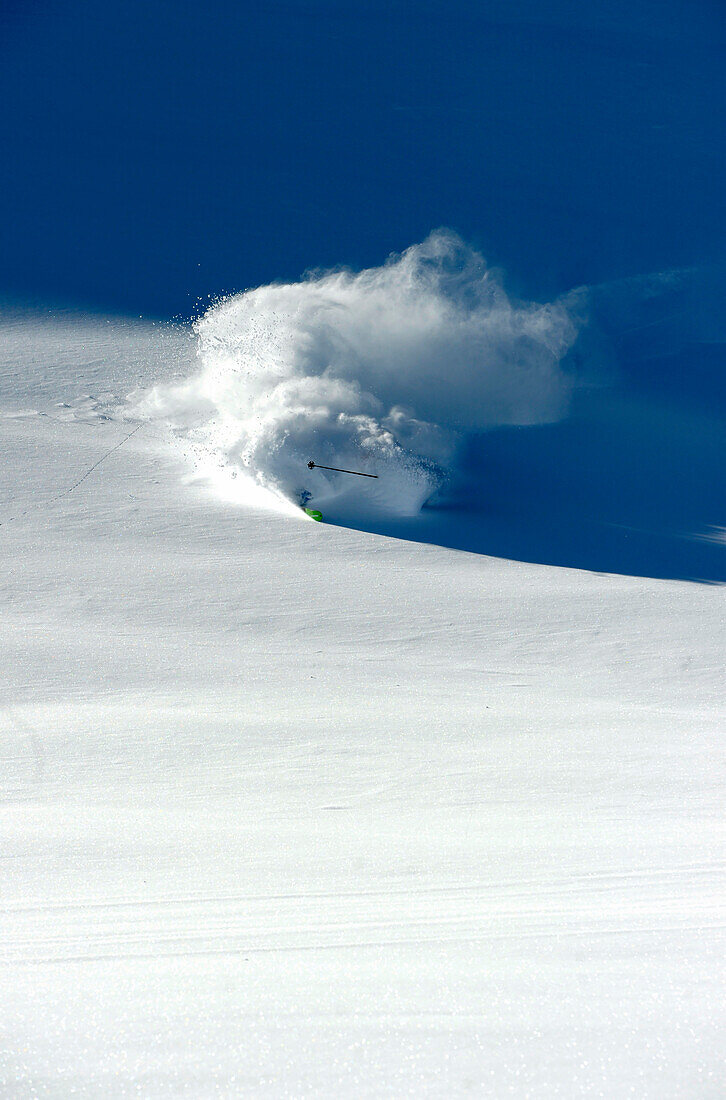 Skier disappearing in powder cloud with only the pole showing, Hintertuxer glacier, Zillertal, Austria