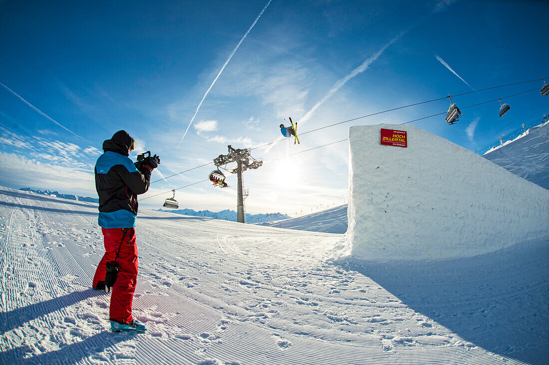 Skifahrer im Funpark fliegt über große Schanze, Kameramann filmt Betterpark, Kaltenbach, Zillertal, Österreich
