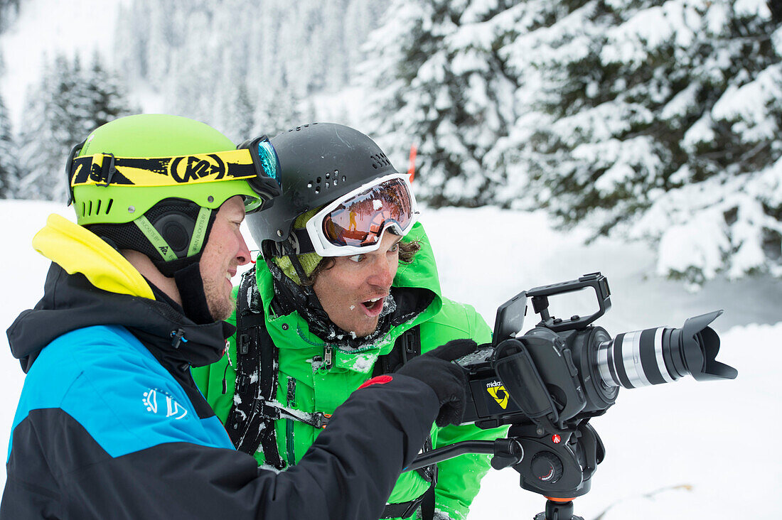 Cameraman showing skier the recording of his skiing on a camera display, Skiing