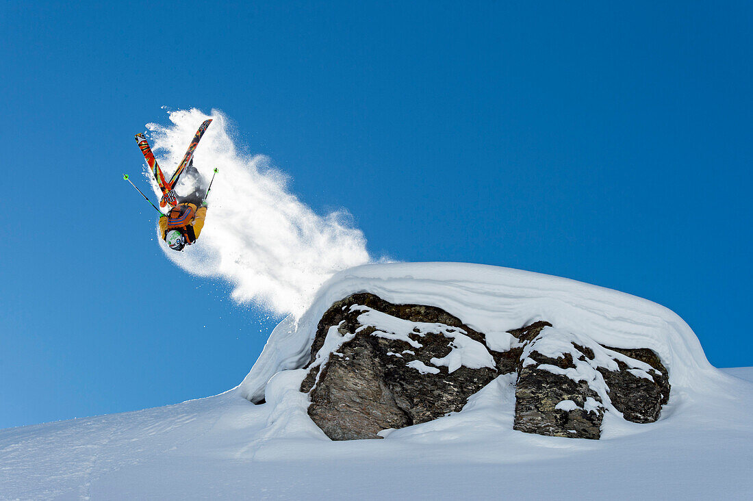 Skier doing a back flip and leaving a snowtail, Hochfuegen, Zillertal, Austria