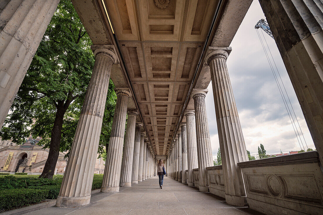 Young lady walking between the columns at the Old National Gallery, Alte Nationalgalerie, Museum Island, Berlin, Germany
