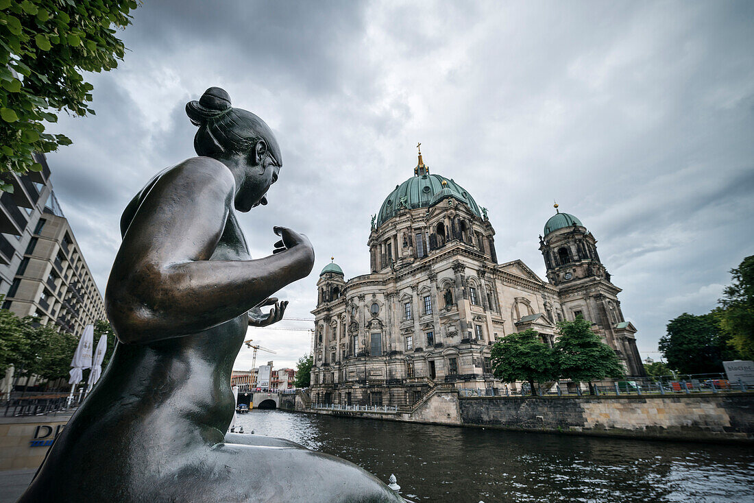 Nude sculpture of woman along the banks of the river Spree facing the Berlin cathedral, Berliner Dom, Museum Island, capital Berlin, Germany