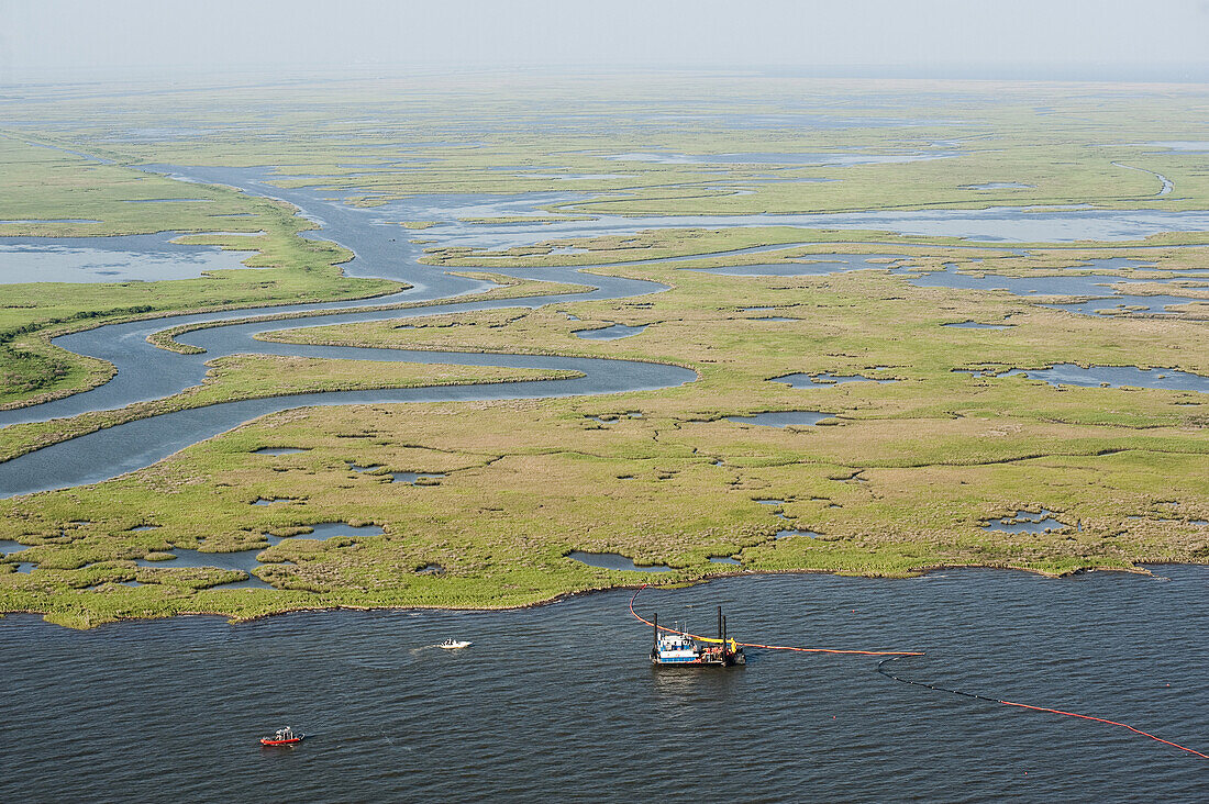 Bayou Catherine - east of New Orleans - May 7, 2010, A boat laden with oil containment booms sets protective measures along a channel leading to Lake Ponchatrain. .