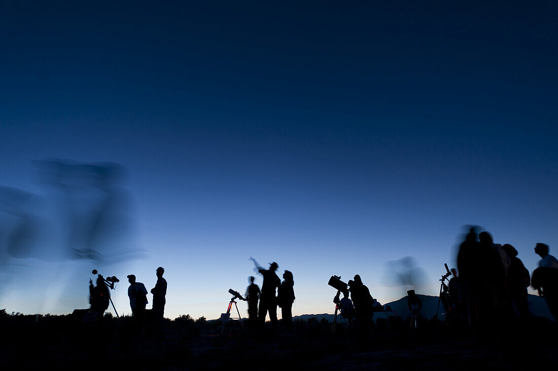 A group of people look at stars and other celestial objects through telescopes during a star gazing party in Great Basin National Park