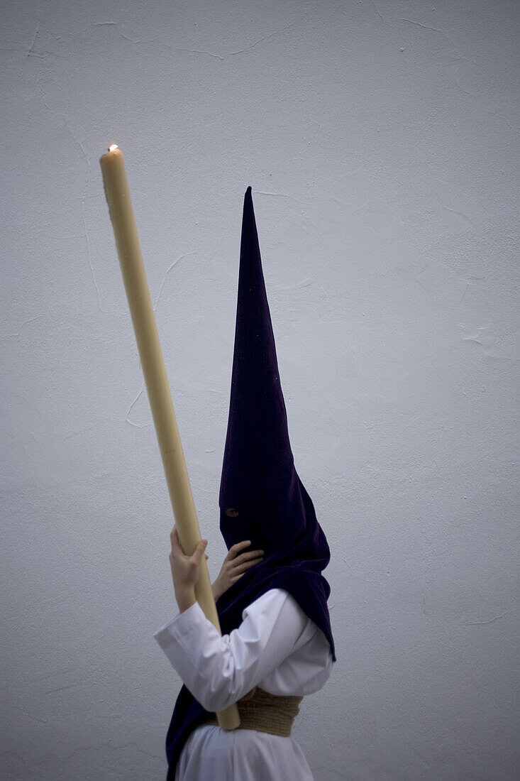 A penitent holds a candle during an Easter Holy Week procession in Carmona village, Seville province, Andalusia, Spain, April 19, 2011.