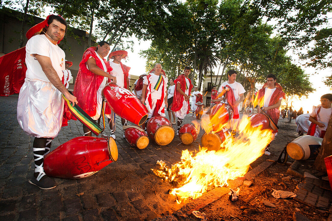 'A group of men heating the drums before playing at the ''desfile de llamadas'' during the carnival celebrations in Colonia del Sacramento, Uruguay.'