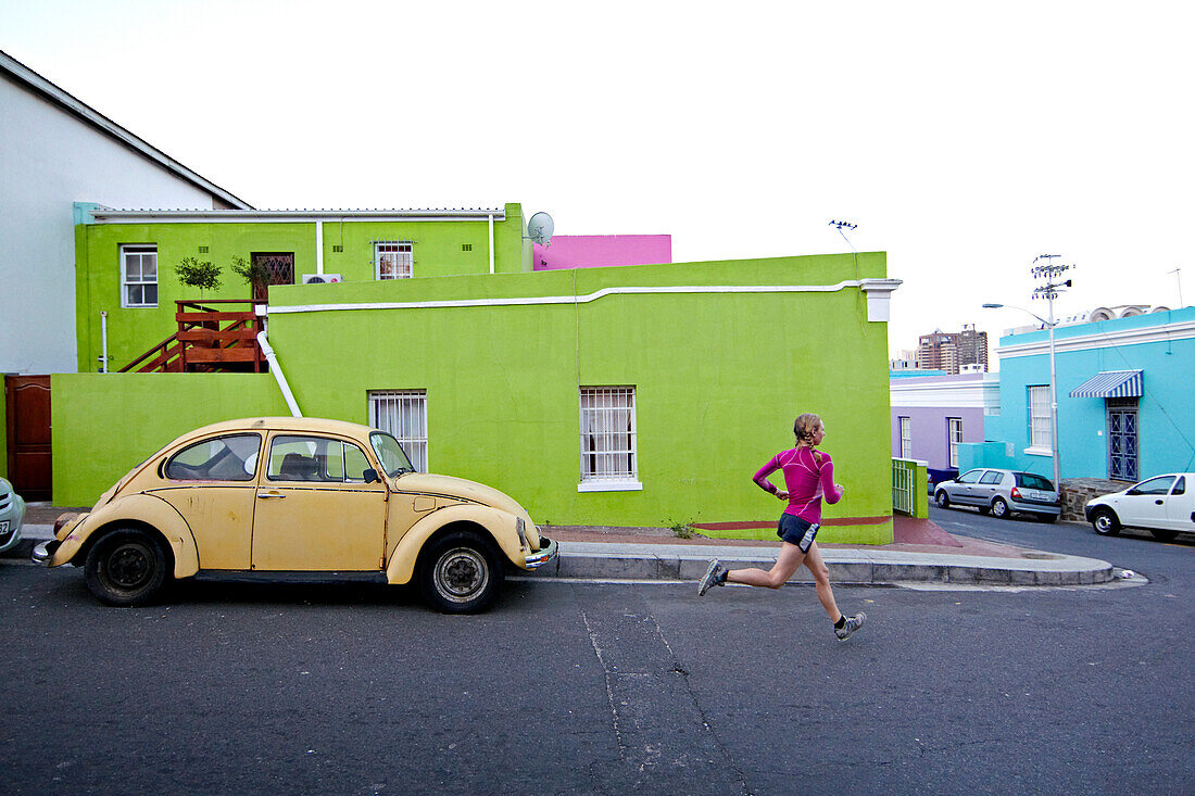 Katrin Schneider running trough the streets of the very colorful Bo-Kaap or Capa Malay Quarter of Cape Town. South Africa.