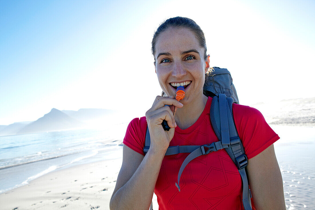 Susann Scheller smiling at the camera while drinking from her hydration pack, while hiking on the Hoerikwaggo Trail from Cape Point to Table Mountain in Cape Town. South Africa.