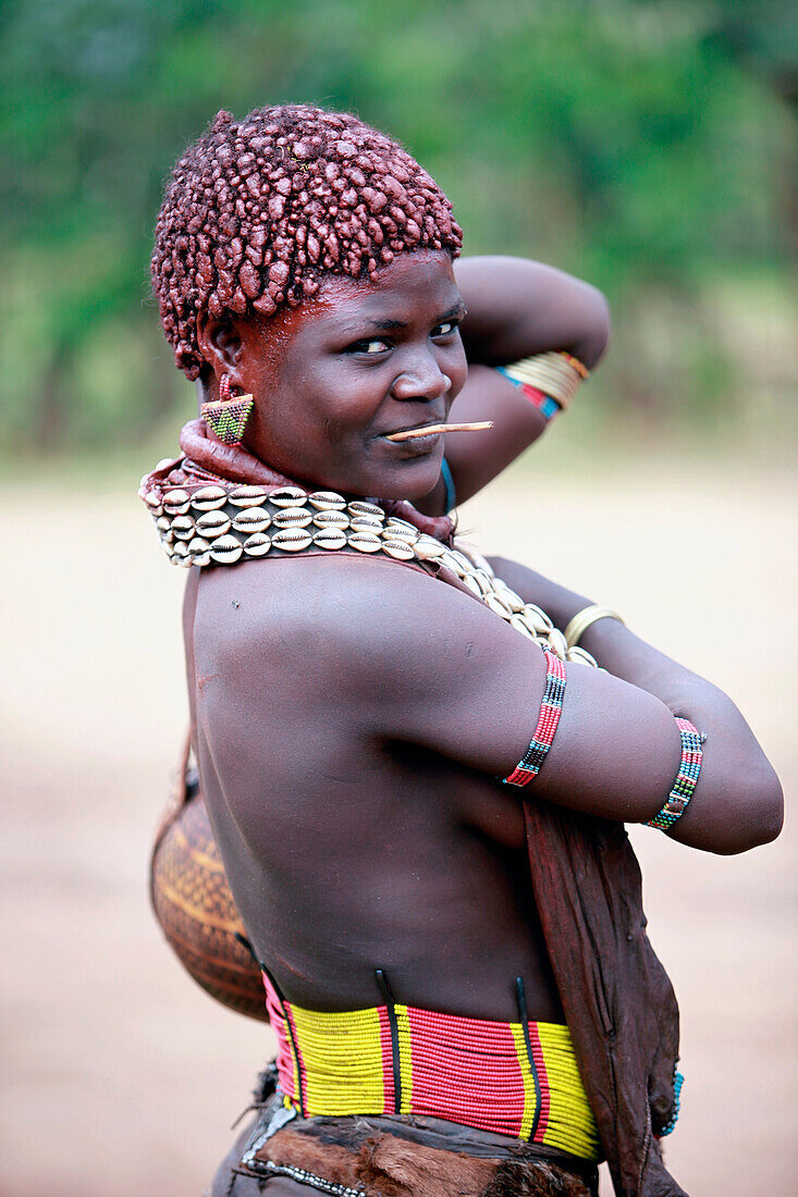 Hamar women adorn their necks with heavy polished iron jewelry and roll their locks with fat and red ochre assile, and than twist them into crimson-colored dreads called Goscha, a style that men find attractive.  Dimeka, Ethiopia, 2010  Dimeka, Omo Valley