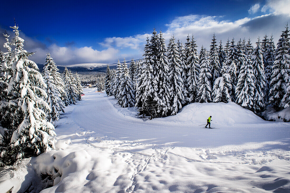 A person cross-country skiing in a beautiful winter landscape at the Izery mountains in Jakuszyce, Poland.