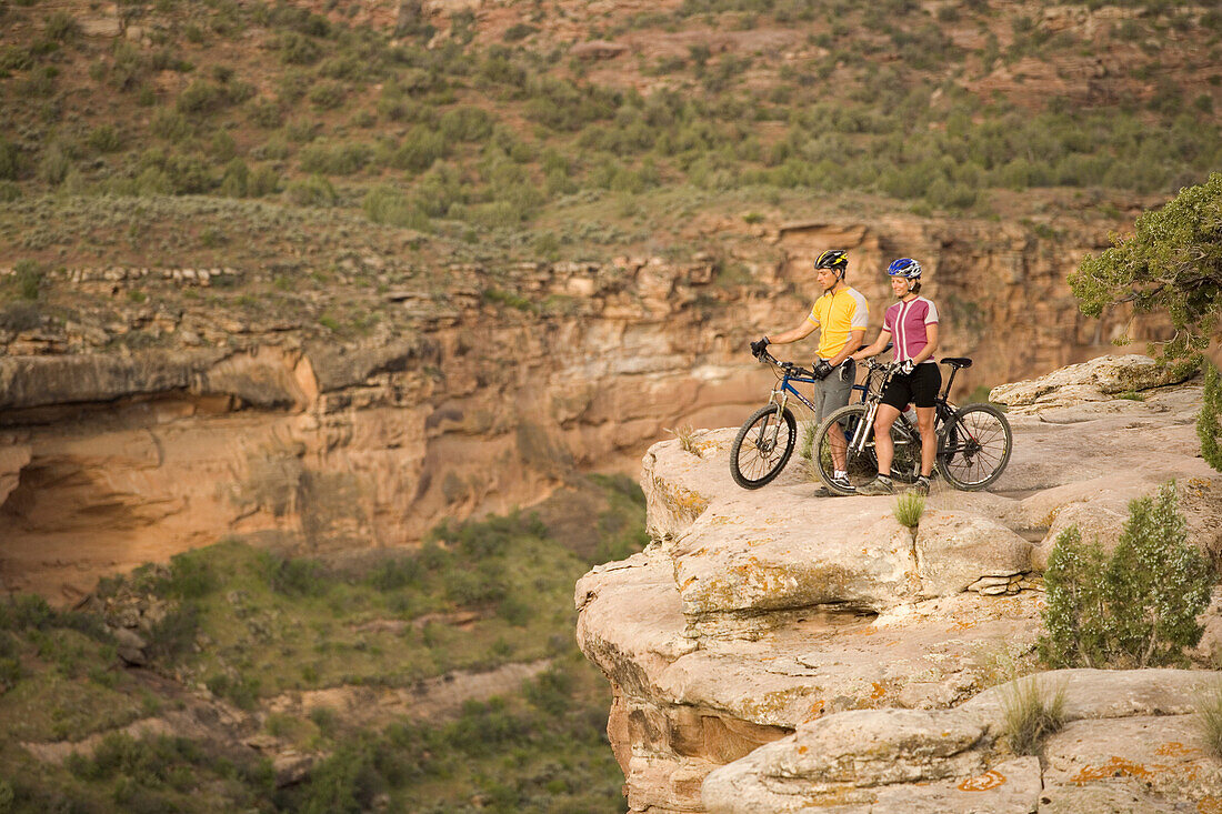 Mountain biker couple enjoying the veiw of the Colorado River, from Horse Thief Bench Trail, near Fruita, Colorado.