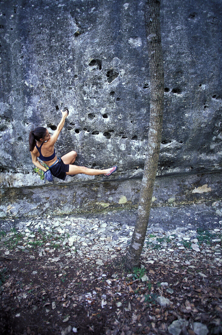 Rebecca Gonzales reaches into her chalk bag while bouldering on pocketed limestone near Austin, Texas.