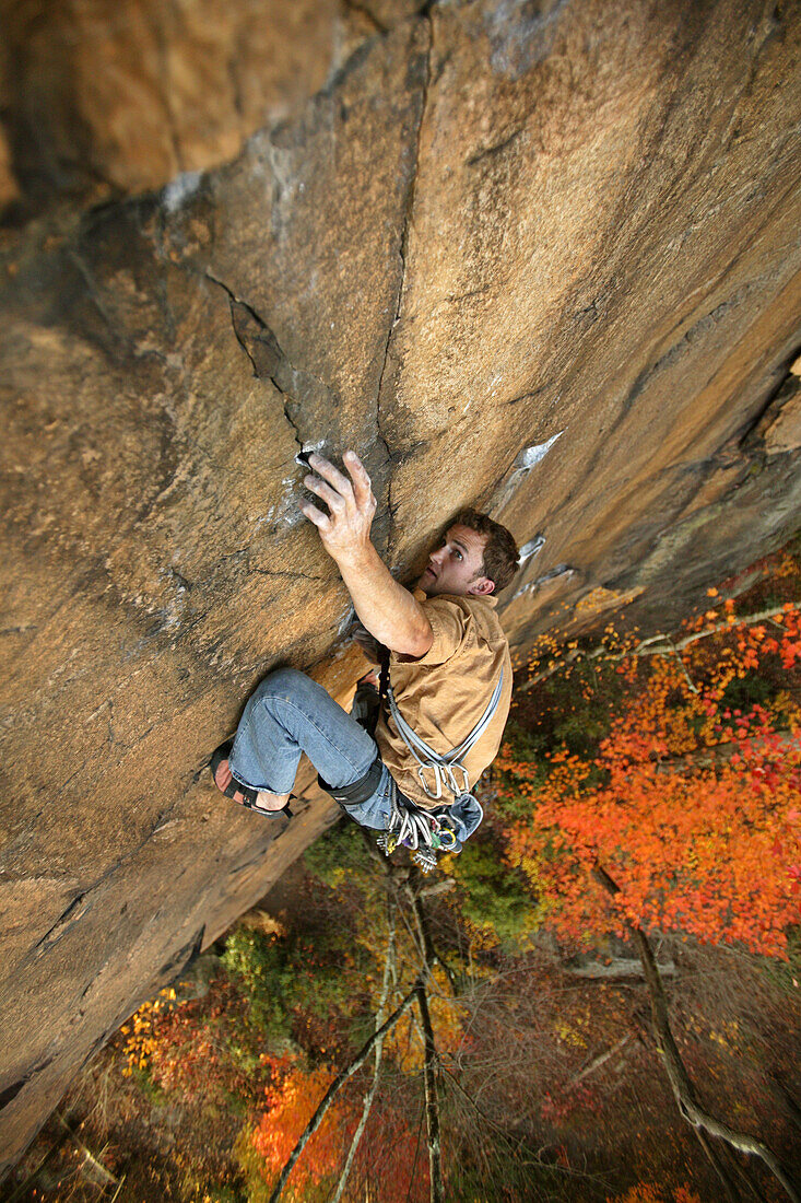 'Robert Thomas digs into the fingerlocks on ''Leave It To Jesus'' 5.11c, at Central Endless Wall at the New River Gorge, WV with vivid fall colors.'