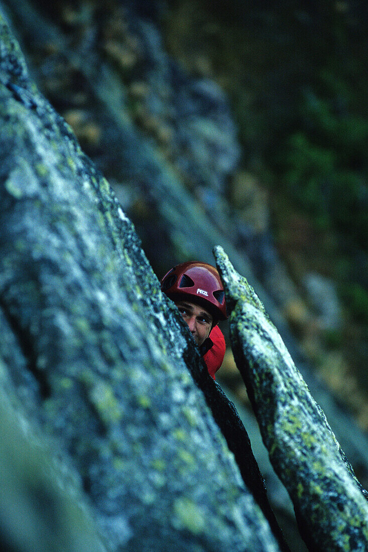 Tim Kemple peeks past a flake while climbing the third pitch of the Armadillo Ridge 5.7, on Mt Katahdin in Baxter State Park, ME.