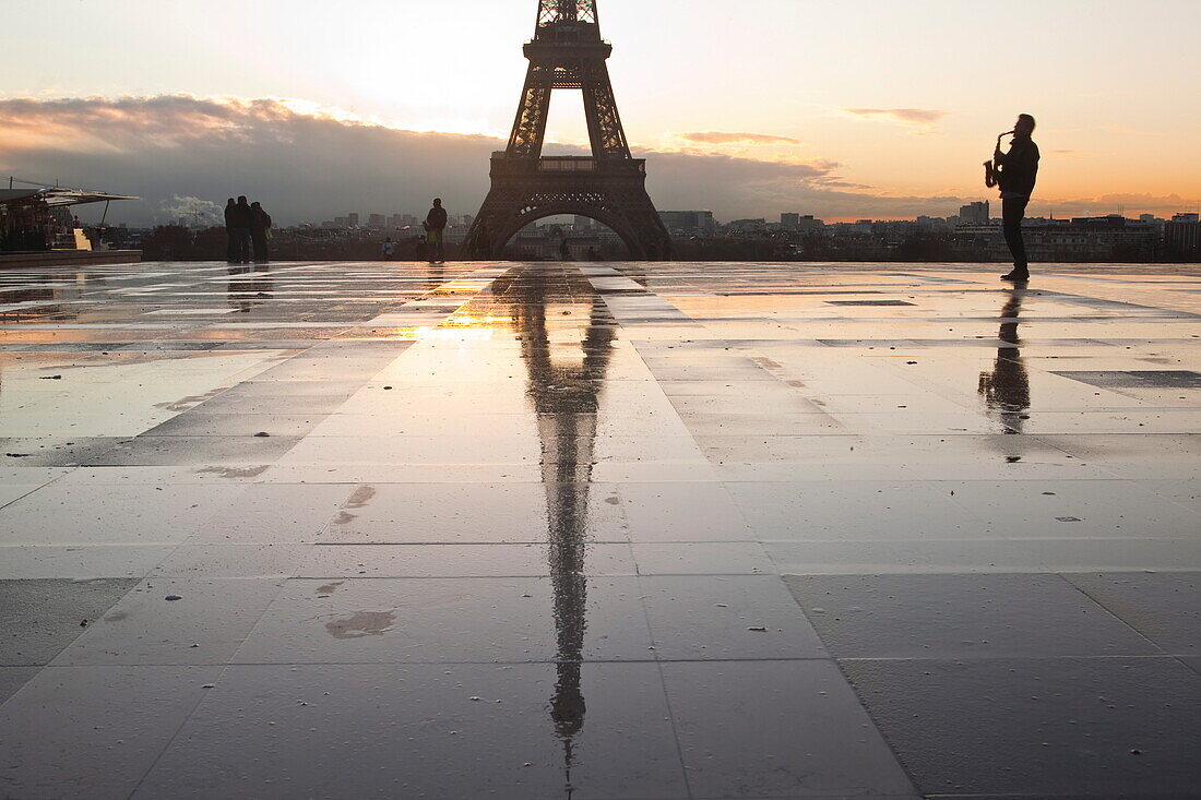 A man playing a saxophone in front of the Eiffel Tower, Paris, France, Europe