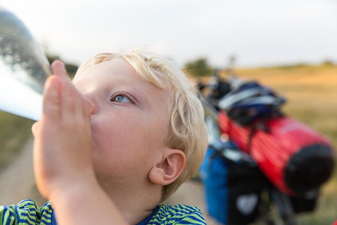 Junge (4 Jahre) trinkt aus einer Wasserflasche, Marielyst, Falster, Dänemark