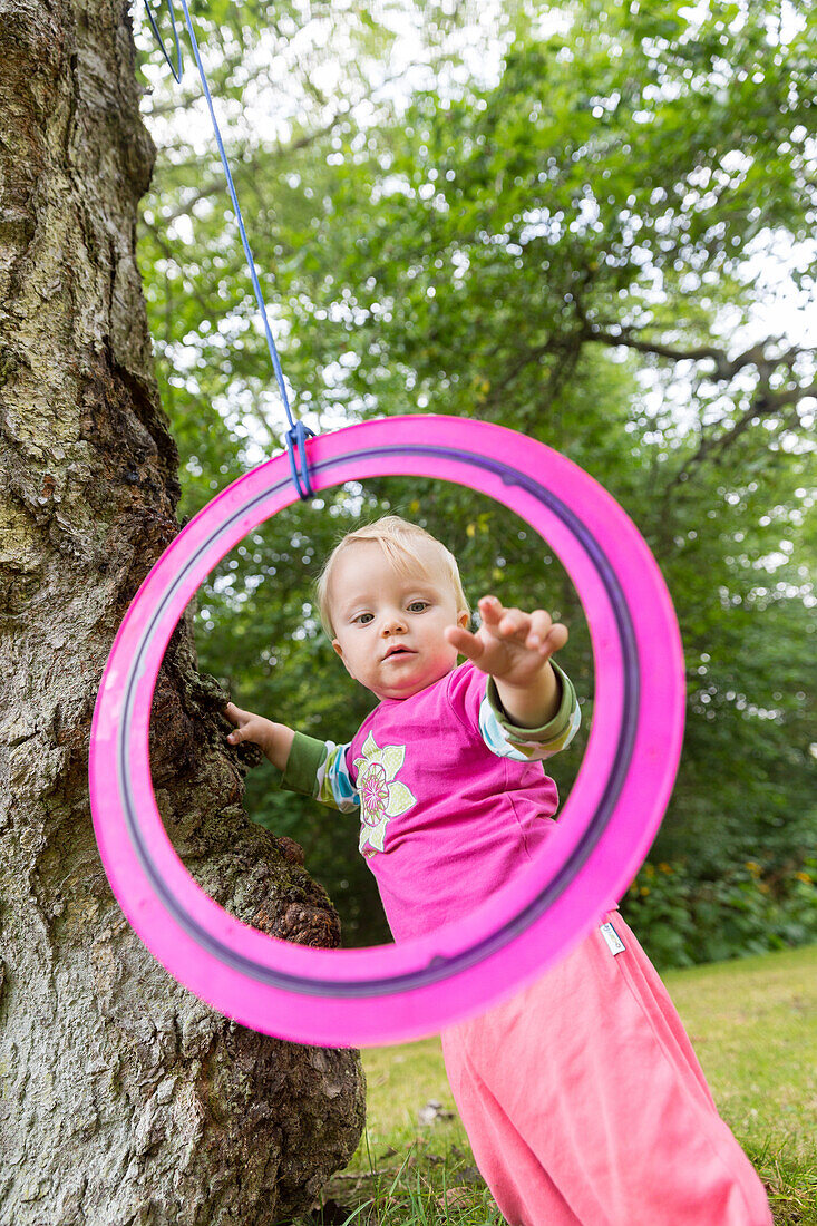 Girl (1 year) looking through a ring, Klintholm, Mon island, Denmark