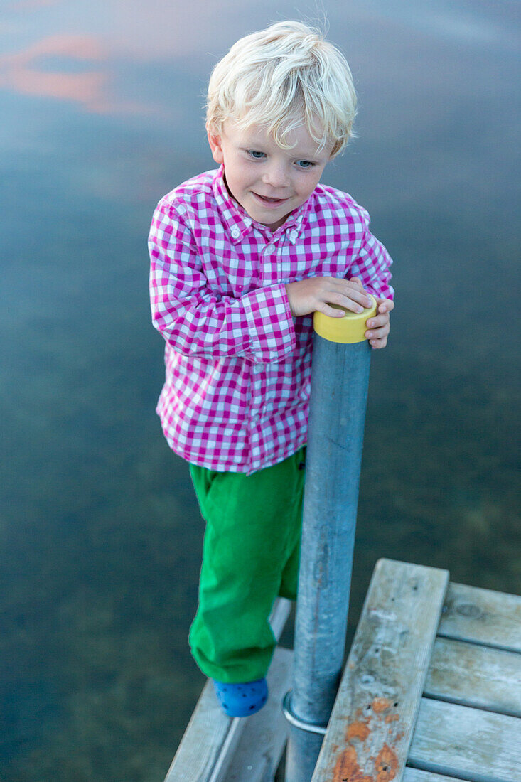 Junge (4 Jahre) balanciert auf einem Bootssteg, Gedser, Falster, Dänemark